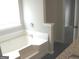 Bathroom showcasing a modern tub with tile, granite counter, and a view into an adjacent space at 4383 Chestnut Lake Ave, Lithonia, GA 30038