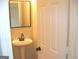 Cozy half-bathroom with a pedestal sink and framed mirror at 4383 Chestnut Lake Ave, Lithonia, GA 30038