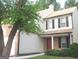 Exterior view of a two-story house with neutral siding and a red front door beneath a covered porch at 4383 Chestnut Lake Ave, Lithonia, GA 30038
