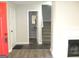 Bright foyer featuring wood-look floors, a red front door, and stairs leading to the upper level at 4383 Chestnut Lake Ave, Lithonia, GA 30038