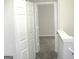Bright hallway with carpet and white trim, showcasing a doorway to another room and a closet at 4383 Chestnut Lake Ave, Lithonia, GA 30038