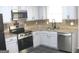 Updated kitchen with stainless steel appliances, granite countertops, and tile backsplash at 4383 Chestnut Lake Ave, Lithonia, GA 30038