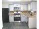 Modern kitchen with white cabinets, stainless steel appliances, and tiled backsplash at 4383 Chestnut Lake Ave, Lithonia, GA 30038