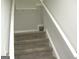 Carpeted staircase with white railings, providing access to the upper level of the home at 4383 Chestnut Lake Ave, Lithonia, GA 30038
