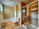 Bathroom with tile flooring and combination tub and shower behind a glass door at 180 Oakland Hills Way, Lawrenceville, GA 30044