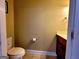 Cozy half bathroom with a toilet, vanity, and tan walls illuminated with natural light at 180 Oakland Hills Way, Lawrenceville, GA 30044