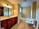 Bathroom featuring tile flooring, vanity with drawers, combination tub and shower and updated lighting at 180 Oakland Hills Way, Lawrenceville, GA 30044