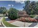 Welcoming brick community sign with colorful flowers and lush landscaping under a clear blue sky at 180 Oakland Hills Way, Lawrenceville, GA 30044