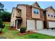Inviting townhome featuring a two-car garage, tidy landscaping, and a mix of brick and siding for a modern feel at 180 Oakland Hills Way, Lawrenceville, GA 30044