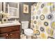 Well-lit bathroom featuring a vanity with sink, toilet, and decorative shower curtain at 230 Haleys Ct, Woodstock, GA 30188