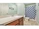 Well-lit bathroom featuring a shower with a patterned curtain, a vanity, and ample counter space at 230 Haleys Ct, Woodstock, GA 30188