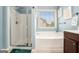Bathroom boasting walk-in shower, bathtub, and a large window for ample natural light at 230 Haleys Ct, Woodstock, GA 30188
