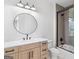 Modern bathroom features a decorative mirror, vanity with a quartz countertop, and tub/shower combo at 915 Laurel Brooke Ave, Peachtree City, GA 30269