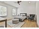 Bright bedroom features hardwood flooring, neutral decor, ceiling fan, and large windows for natural light at 915 Laurel Brooke Ave, Peachtree City, GA 30269