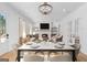 Dining room with a fireplace, large chandelier, table set for a meal, and living space beyond at 915 Laurel Brooke Ave, Peachtree City, GA 30269