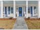 Charming front porch with large supporting columns and dark blue door and window shutters at 915 Laurel Brooke Ave, Peachtree City, GA 30269