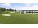 Picturesque golf course view with sand traps, manicured greens, and stunning lake backdrop at 915 Laurel Brooke Ave, Peachtree City, GA 30269