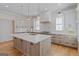 Bright kitchen featuring a large center island, wooden accents, modern appliances, and white cabinetry at 915 Laurel Brooke Ave, Peachtree City, GA 30269