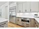 Kitchen features stainless steel refrigerator, white cabinets and countertops, with wood toned drawers and cabinets at 915 Laurel Brooke Ave, Peachtree City, GA 30269