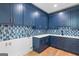 Inviting laundry room with blue cabinets, quartz countertops, and decorative backsplash at 915 Laurel Brooke Ave, Peachtree City, GA 30269