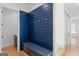 Inviting mudroom features blue accent wall with hooks and a built-in bench at 915 Laurel Brooke Ave, Peachtree City, GA 30269