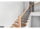 Bright staircase with wood stairs, black metal balusters, and white walls at 915 Laurel Brooke Ave, Peachtree City, GA 30269