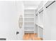 Bright walk-in closet features custom shelves and a round mirror for added style at 915 Laurel Brooke Ave, Peachtree City, GA 30269