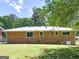 Spacious backyard showcasing a brick home with multiple windows and a lush green lawn at 3548 Meadowview Ct, Rex, GA 30273