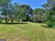 Expansive backyard with lush green grass and mature trees offering shade and privacy at 3548 Meadowview Ct, Rex, GA 30273