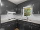 Traditional kitchen features black cabinets and granite countertops at 3548 Meadowview Ct, Rex, GA 30273