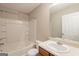 Bright bathroom with a tub-shower combination and a vanity with sink at 1851 Grove Way, Hampton, GA 30228