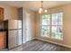 Bright dining area featuring stainless steel refrigerator, laminate flooring, and a large window at 1851 Grove Way, Hampton, GA 30228