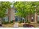 Inviting townhome featuring stone and brick accents, front yard with lush trees and landscaping at 1851 Grove Way, Hampton, GA 30228