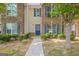 Charming townhome featuring stone and brick accents, a walkway, and lush landscaping at 1851 Grove Way, Hampton, GA 30228