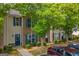 View of the townhouse-style homes with traditional design elements, blue shutters, and well maintained front yard at 1851 Grove Way, Hampton, GA 30228