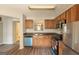 Well-equipped kitchen with stainless steel appliances, wood cabinets, and laminate flooring at 1851 Grove Way, Hampton, GA 30228
