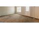 Spacious living room featuring neutral-colored walls, a large window, and a door at 1851 Grove Way, Hampton, GA 30228