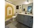 Well-lit bathroom features modern gray vanity with black hardware and stylish gold shower curtain at 401 Bainbridge Dr, Mcdonough, GA 30253