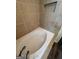 Inviting bathroom features a luxurious white soaking tub with whirlpool jets and tile surround at 2884 Mountbery Dr, Snellville, GA 30039