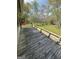 A wooden deck with a view of a green lawn and trees, providing ample space at 2884 Mountbery Dr, Snellville, GA 30039