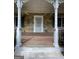 Inviting front porch with stone facade, white pillars, and a decorative railing at 2884 Mountbery Dr, Snellville, GA 30039