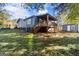 Backyard with wooden deck, stairs and weathered shed surrounded by lush trees at 389 Oglesby Bridge, Conyers, GA 30094