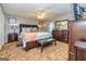 This bedroom features a large bed with nightstands, ceiling fan, and carpet flooring at 6500 Wild Turkey Trl, Riverdale, GA 30296