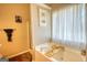 Bathroom featuring soaking tub, wooden accents, and a separate shower at 50 Berkshire Pass, Covington, GA 30016