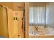 Bright bathroom features a soaking tub with a bamboo tray and a glass enclosed shower at 50 Berkshire Pass, Covington, GA 30016
