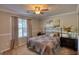 Inviting bedroom features neutral walls, plush carpet, ceiling fan, and a decorative quilt at 50 Berkshire Pass, Covington, GA 30016