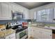 Bright kitchen with stainless steel appliances, granite countertops and custom white cabinets at 50 Berkshire Pass, Covington, GA 30016