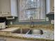 Close-up of the kitchen sink with granite countertops and a window view at 50 Berkshire Pass, Covington, GA 30016