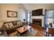 Comfortable living room showcasing fireplace, TV, hardwood floors, and natural light at 50 Berkshire Pass, Covington, GA 30016
