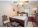 Inviting bedroom with ceiling fan, decorative pillows on the bed, and a dresser with a vintage lamp at 1346 Revelstoke Cv, Riverdale, GA 30296